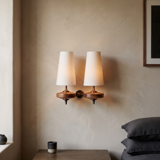 Nikau sconce lit on a warm plaster wall