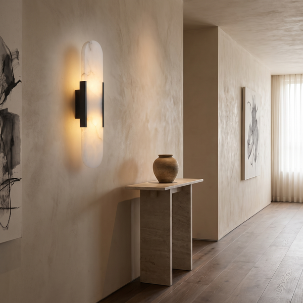 Melange alabaster sconce on a plaster hallway wall above a stone console