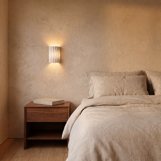 Ujal compact 6.4-inch wall sconce beside a bed