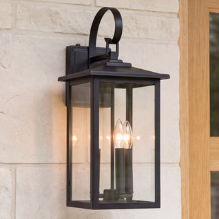 Lanverro black three-light glass wall lantern, close installed view with bulbs on
